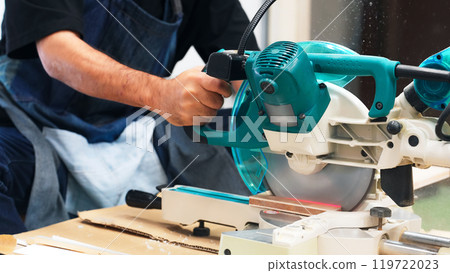 A man cutting wood using an electric saw - DIY A man cutting wood using an electric saw - DIY 119722023