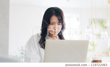 一個女人在看筆記本電腦時擔心 119722063