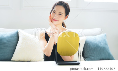 A woman doing skin care in the mirror indoors 119722107