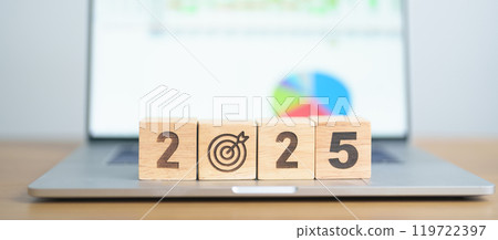 2025 Year block with dartboard icon against computer laptop background. Goal, Target, Resolution, strategy, plan, Action, mission, motivation, and New Year start concepts 119722397
