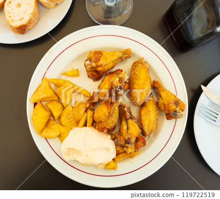 Roasted chicken wings french fries on a plate cooked in cafe 119722519