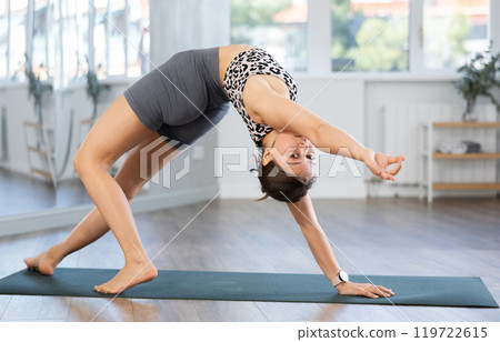 Young woman practicing vinyasa yoga in studio Young woman practicing vinyasa yoga in studio 119722615