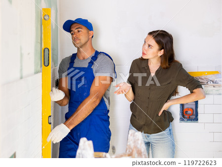 Woman dissatisfied with work done by the builder to renovate bathroom 119722623