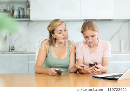 Girl shows mother friends account on social network on phone, parents are interested in considering Girl shows mother friends account on social network on phone, parents are interested in considering 119722631