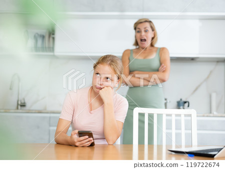 Mother scolds teenage girl for wasting time and sticking in phone. Gadgets and family Mother scolds teenage girl for wasting time and sticking in phone. Gadgets and family 119722674