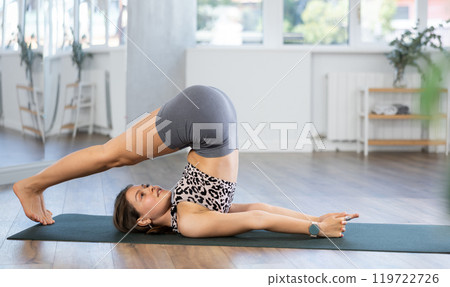 Young woman practicing vinyasa yoga in studio 119722726