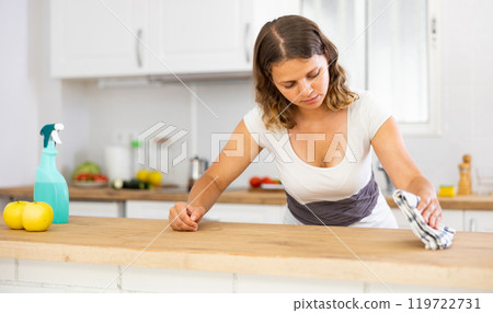 Young woman cleaning kitchen countertop at home Young woman cleaning kitchen countertop at home 119722731