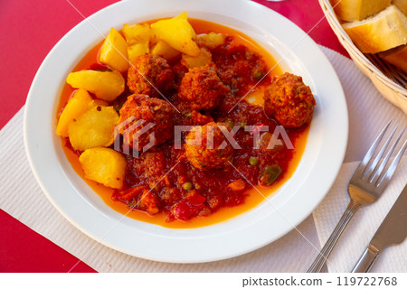 Albondigas meatballs with vegetable salsa and potato garnish 119722768