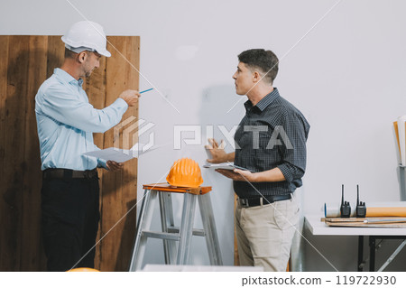 Team Engineers with draft plan of building on constructing site. Engineer work on site. engineer visit and inspection site engineer. Inspector engineer check and working on site. Team Engineers with draft plan of building on constructing site. Engineer work on site. engineer visit and inspection site engineer. Inspector engineer check and working on site. 119722930