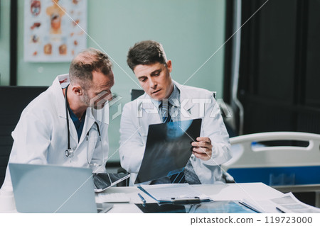 Group of medical practitioners working together and analyzing medical scan in the hospital 119723000