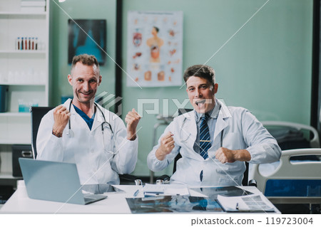Smiling young male clinician shake hands with happy teammate appreciate for assistance on surgery show support respect on team council. Two doctors partners handshaking making deal reaching agreement 119723004