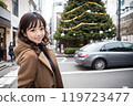 A woman stops her car to take a commemorative photo in front of a Christmas tree 119723477