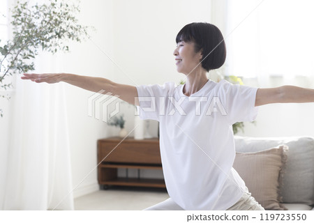 Middle-aged woman doing yoga in her room 119723550