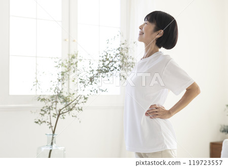 Middle-aged woman doing exercises in the room Middle-aged woman doing exercises in the room 119723557