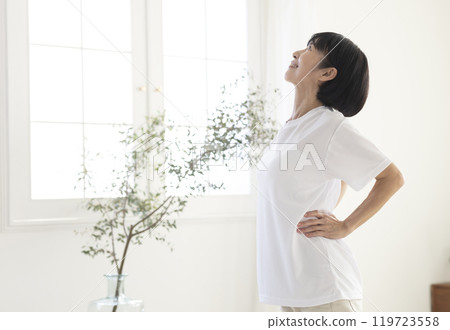 Middle-aged woman doing exercises in the room 119723558