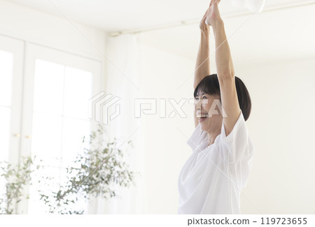 Middle-aged woman doing exercises in the room Middle-aged woman doing exercises in the room 119723655