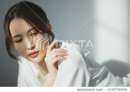 Young woman by the window Young woman by the window 119724048
