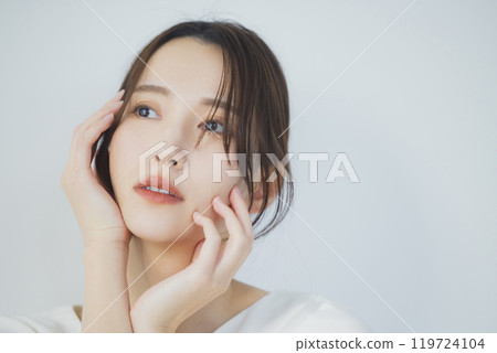 Young woman by the window 119724104