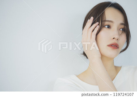 Young woman by the window 119724107