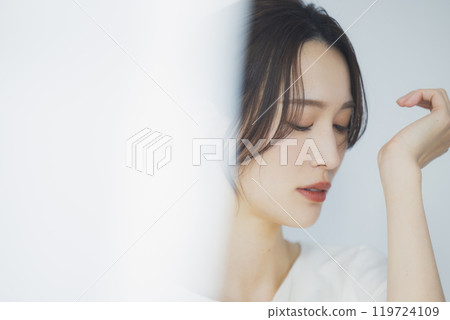Young woman by the window Young woman by the window 119724109