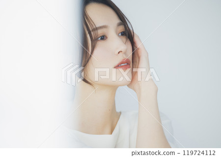 Young woman by the window Young woman by the window 119724112