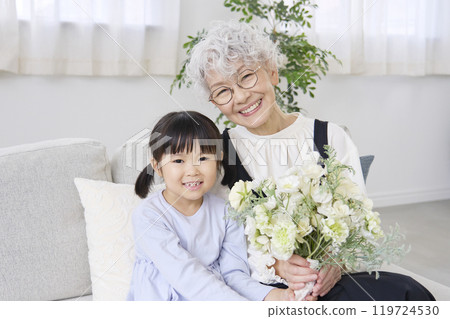 Grandmother and grandchild holding bouquet, living room, looking at camera Grandmother and grandchild holding bouquet, living room, looking at camera 119724530