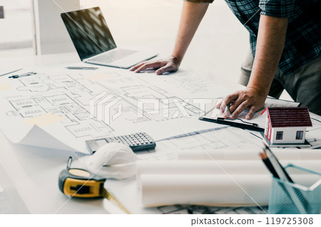 Engineers are designing working on blueprints and analyzing the structure of the project. Engineers are designing working on blueprints and analyzing the structure of the project. 119725308