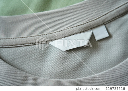 Close up of blank white clothing care label on shirt fabric background. 119725316