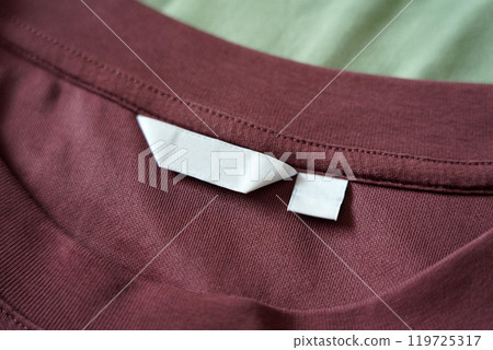 Close up of blank white clothing care label on shirt fabric background. 119725317