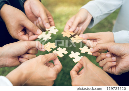 group of business people assembling jigsaw puzzle. The concept of cooperation, teamwork, help and support in business. group of business people assembling jigsaw puzzle. The concept of cooperation, teamwork, help and support in business. 119725320