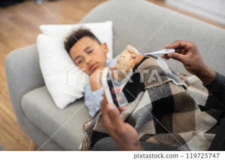 Father cares for sick child during video call with doctor Father cares for sick child during video call with doctor 119725747