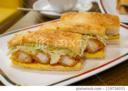 The cut-out of the fried shrimp sandwich on the plate looks tempting The cut-out of the fried shrimp sandwich on the plate looks tempting 119726033