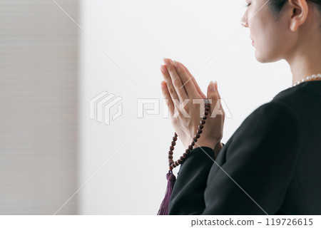 A woman in mourning clothes holding hands A woman in mourning clothes holding hands 119726615