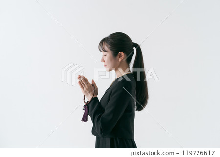 A woman in mourning clothes holding hands A woman in mourning clothes holding hands 119726617