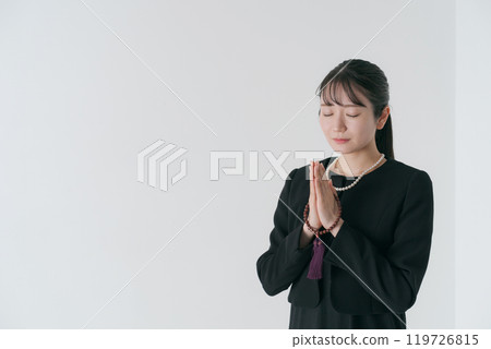 A woman in mourning clothes holding hands 119726815