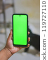 Person Holding Smartphone with Green Screen Display 119727110
