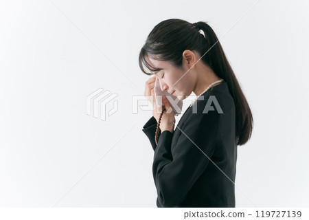 A woman in mourning clothes shedding tears 119727139