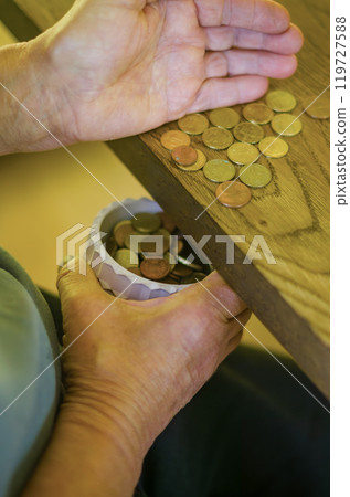 adult senior hands Sorting Small Change into a Container on a Wooden Table. High quality photo 119727588