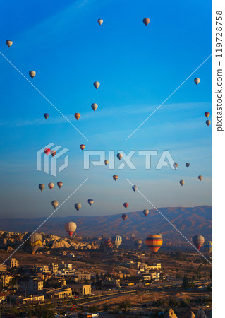 Colorful hot air balloons fly gracefully over a vibrant skyline in valley Cappadocia Turkey 119728758