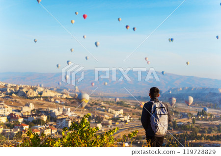 Person man watch hot air balloons over a city in Cappadocia 119728829