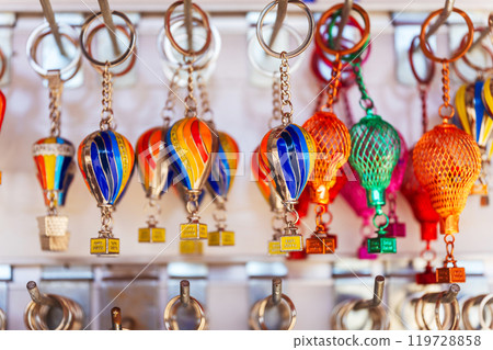 A vibrant collection of colorful hot air balloons keychains suspended on wall in souvenir shop A vibrant collection of colorful hot air balloons keychains suspended on wall in souvenir shop 119728858