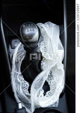 White lace women's panties near the gearshift lever in the car White lace women's panties near the gearshift lever in the car 119728947