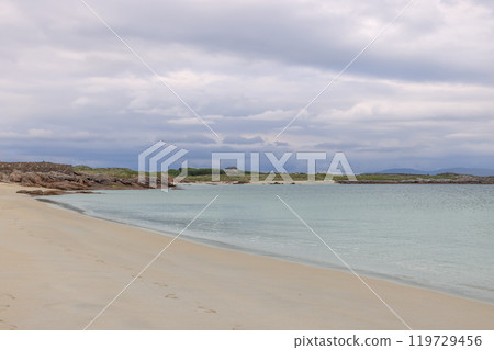 Quiet Gurteen Bay sunset scene sandy shore Atlantic waters gentle waves and overcast Irish coastline 119729456