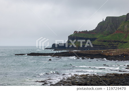 Giant Causeway filled with visitors exploring famous basalt columns rugged cliffs Atlantic coastline 119729470