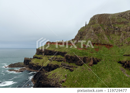 Coastal cliffs at Giant Causeway black basalt red rock layers overlooking rough Atlantic Ocean Coastal cliffs at Giant Causeway black basalt red rock layers overlooking rough Atlantic Ocean 119729477