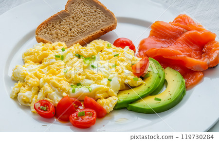 Scrambled eggs with avocado and tomato. Concept of healthy breakfast. 119730284