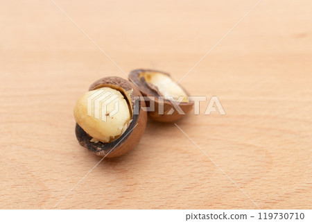 Macadamia nuts on wooden board. 119730710