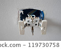 Electrical wires sticking out from electrical socket hole 119730758