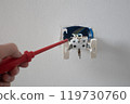 Professional electrician working on a home electrical system is installing a wall socket 119730760