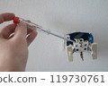 Professional electrician working on a home electrical system, he is changing a wall socket 119730761